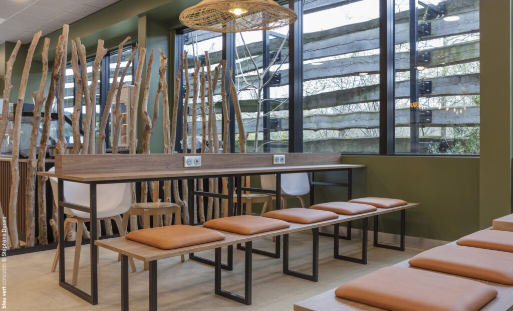 Tables et assises en bois face aux baies